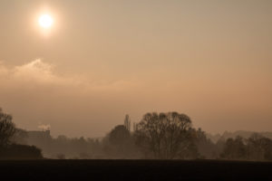 Sonne hinter Wolken über einem Waldstück. Sonne hinter Wolken über einem Waldstück.